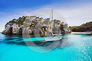 Beautiful beach with sailing boat yacht, Cala Macarelleta, Menorca island, Spain. Yachting, travel and active lifestyle concept