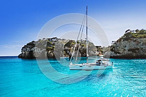 Beautiful beach with sailing boat yacht, Cala Macarelleta, Menorca island, Spain. Yachting, travel and active lifestyle concept