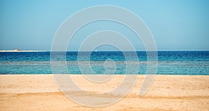 Beautiful beach with sand, blue sky, water with boat