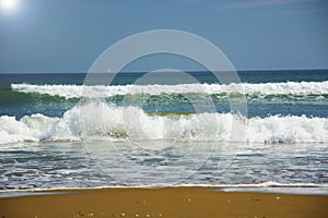 Beautiful beach, on the sand roll frothy waves