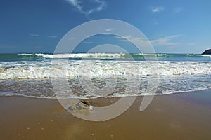 Beautiful beach, on the sand roll frothy waves