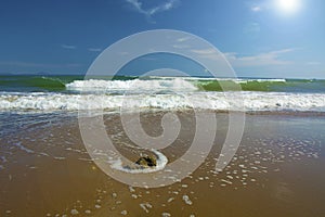 Beautiful beach, on the sand roll frothy waves