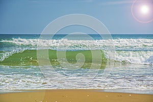 Beautiful beach, on the sand roll frothy waves