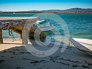 Beautiful beach with stone jetty and boats in Algarve, Portugal. photo