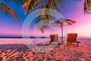 Beautiful beach sunset, two sun chairs with umbrella, twilight sky. Luxury vacation and holiday concept