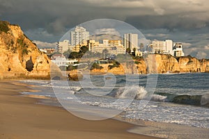 Beautiful beach view of the city of PortimÃ£o, Algarve, Portugal, ocean waves and Praia do Vao beach at sunset