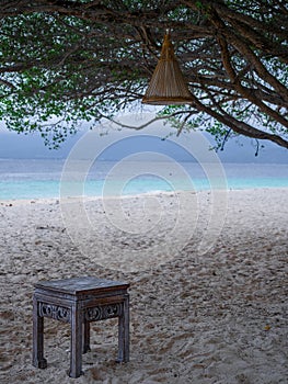 Beautiful beach view on Gili Meno Indonesia between the trees with a stool