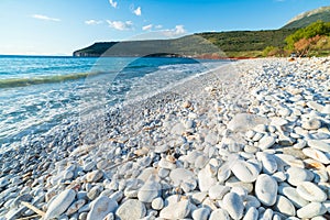 Beautiful beach and water bay in the greek spectacular coast line. Turquoise blue transparent water, unique white pebbles, Greece