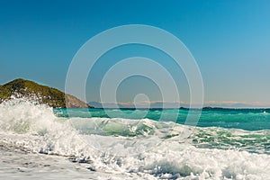 A beautiful beach with waves and a view of the green mountain.  Turkey. Cirali.