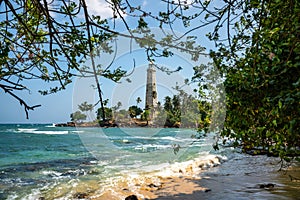 Beautiful beach and White lighthouse Dondra in Sri Lanka. View from the beach.