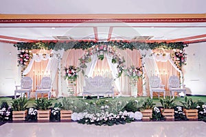 the beautiful and beautiful Gebyok wedding stage is complemented by flower decorations