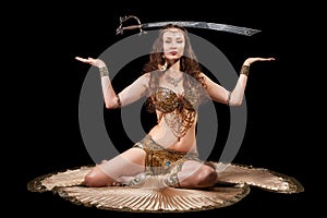 Beautiful belly dancer balancing sword