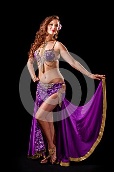 Beautiful belly dancer holding out skirt