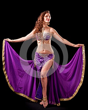 Beautiful belly dancer holding out skirt