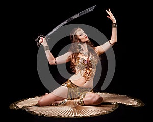 Beautiful belly dancer holding sword up