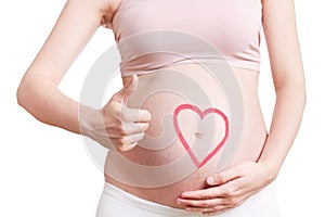 Beautiful belly of young attractive pregnant woman over white background