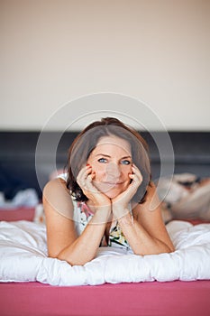 Beautiful best age woman lying on bed relaxing, enjoying life