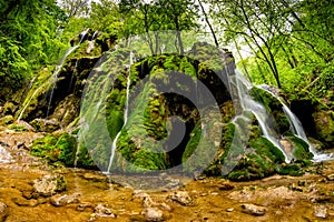 Beautiful Beusnita waterfall in the forest with green moss