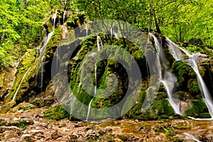 Beautiful Beusnita waterfall in the forest with green moss