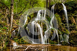 Beautiful Beusnita waterfall in the forest with green moss