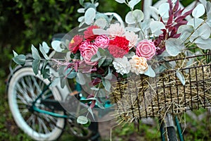 Beautiful bicycle with flowers in a basket stands on an avenue