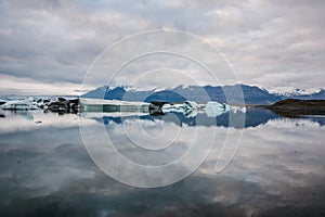 Beautiful big blue iceberg floating in Jokulsarlon glacial, Iceland in summer at dusk, reflecting in the water. Copy space