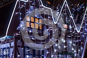 Beautiful big house decorated with Christmas lights. Large Windows with Christmas tree.