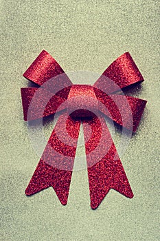 A beautiful big red bow on a silver glittering background.
