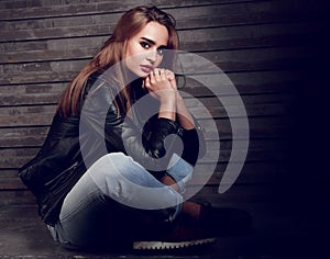 Beautiful biker woman thinking in black fashion jacket and jeans