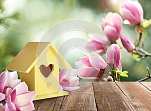 Beautiful bird house on wooden table outdoors, space for text