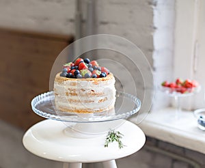 Hermoso galleta pastel blanco crema decorado arándanos sobre el blanco bastidores sobre el 