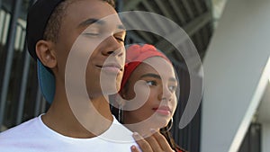 Beautiful black girl hugging confident boyfriend, popular teens in high-school