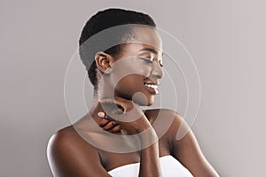 Beautiful black girl touching her velvet skin on neck