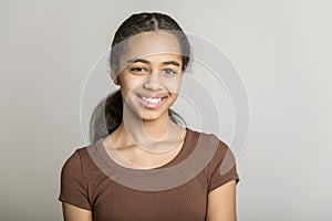 Beautiful black teen posing on studio gray background
