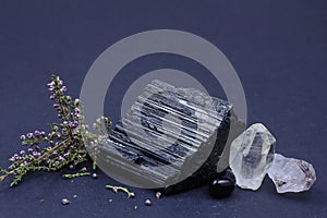 Beautiful black tourmaline , amethyst, smoky quartz on a black background with heather branch