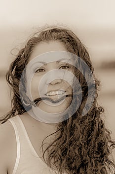 Beautiful black and white image of a happy smiling Mexican woman with long hair tousled by the wind