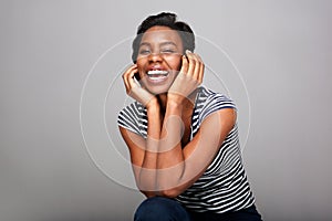 Beautiful black woman laughing with hands on face