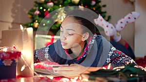 Beautiful black woman is shopping online using laptop and making payment with credit card on Christmas Eve