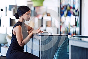 Beautiful black woman using digital tablet while sitting at counter