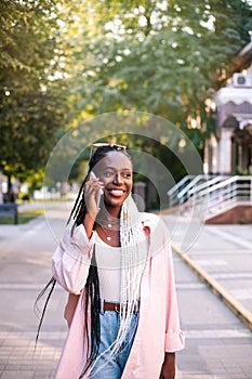 Beautiful black woman using smartphone at street.