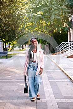 Beautiful black woman walking at street at summer.