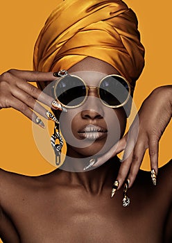 Beautiful black woman with a yellow towel on her head, classic makeup and art manicure. Beauty face.
