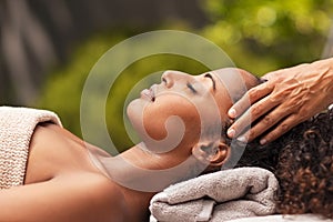 Beautiful african woman relaxing with face massage photo