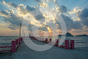 Beautiful blazing sunrises landscape with cloud and sun rays at Ao Prachuap bay with Saranwithi bridge stretching in to the sea