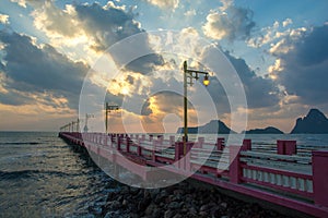 Beautiful blazing sunrises landscape with cloud and sun rays at Ao Prachuap bay with Saranwithi bridge stretching in to the sea