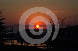 Beautiful blazing sunset landscape at black sea and orange sky above it with awesome sun golden reflection on calm waves as a