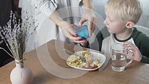 Beautiful blond boy dines at home