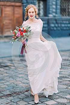Beautiful blond bride walking on streets of Lviv city center