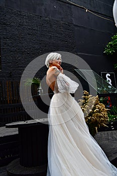 Beautiful blond bride in white dress, naked back and tatoo