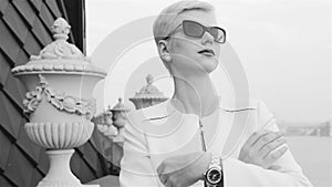 Beautiful blond business women wearing sunglasses white jacket waiting meeting speak phone city streets